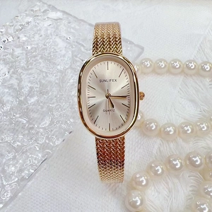 Elegant gold quartz watch with oval dial and mesh strap featuring pearl accessories