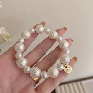 Élastique à cheveux élégant en perles blanches dépolies avec médaille dorée MORAVA