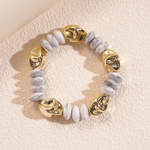 Detail of irregular golden beads and marble texture round beads on a beaded bracelet