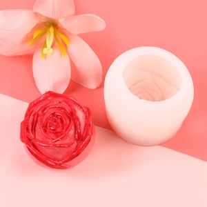 Detail of white 3D rose silicone mold with finished red candle on pink background