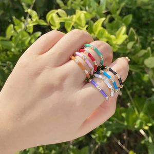 Colorful enamel ring set with cubic zirconia stones in gold plating worn outdoors