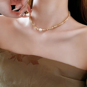 Detail of 14K gold-plated shell bead necklace with a large irregular pearl pendant