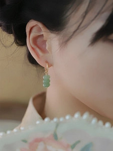 Detail of vintage gold hoop earrings with three vertical green natural aventurine beads