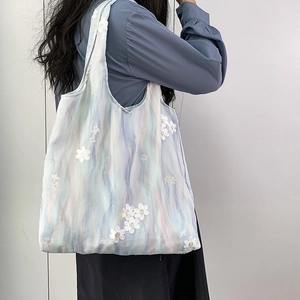 Détail de la broderie fleurie 3D sur un sac fourre-tout en toile dégradée aquarelle