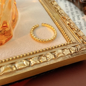 Detail of vintage golden open ring with beaded bubble texture on retro background
