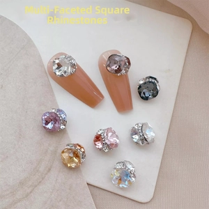 Macro shot of multi-faceted square nail art rhinestones in white and champagne shades