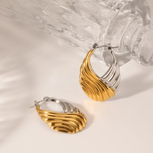 Two-tone wavy stainless steel hoop earrings in gold and silver finish with textured design