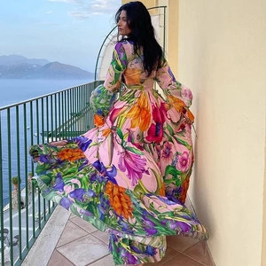 Détail d'une robe longue à imprimé fleuri vif et manches lanternes pour les vacances d'été