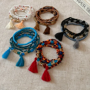 Detail of bohemian multilayer beaded bracelets with colorful beads and silk tassels