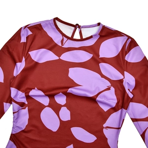 Détail du col rond avec découpe en goutte d'eau et bouton sur la robe imprimée