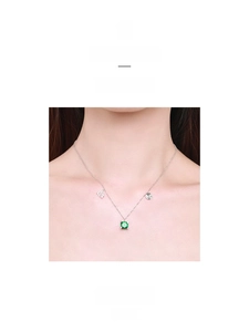 Close-up of S925 silver necklace with green gemstone pendant on female model