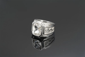 Close-up of a silver dragon ring featuring a clear square gemstone and intricate carvings