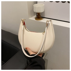 Detailed view of a white crescent moon shoulder bag with gold zipper and smooth texture