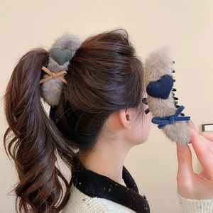 Close-up of plush heart claw clips in grey and tan with velvet bows for hair