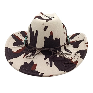Detail of cow print western cowboy hat with turquoise beads and brown drawstring band