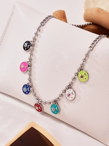 Detailed macro view of colorful drip oil sun and moon pendants on a chunky steel chain