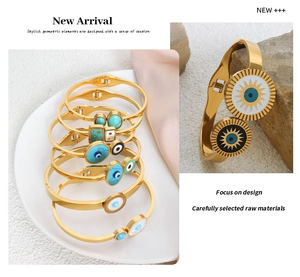 Detailed macro view of gold-plated evil eye and sun charms on boho stainless steel bangles