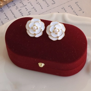 Vintage black and white camellia flower stud earrings with pearl center on velvet