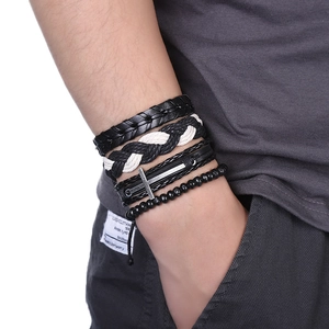 Gros plan d'un ensemble de bracelets multicouches en cuir pour hommes avec croix et perles