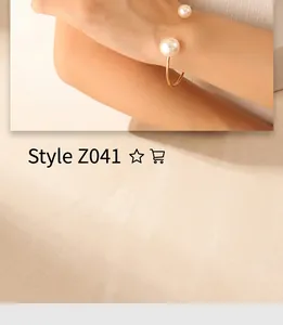 Detail view of adjustable open gold bracelet featuring dual pearls on a model's wrist
