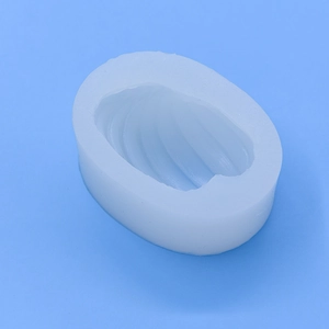 White conch shell silicone mold for DIY candles and soaps on a blue background