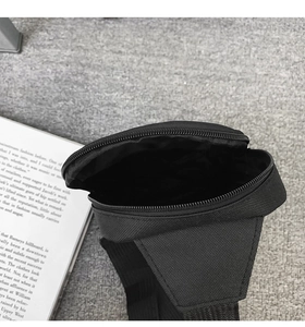 Close-up of black fabric crossbody bag interior showing zipper and storage space