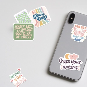 Detail showing waterproof vinyl stickers with inspirational quotes on a phone surface