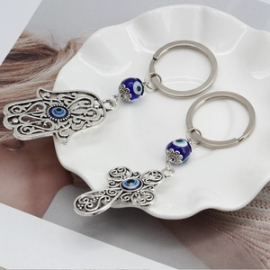 Dettaglio macro di portachiavi Mano di Fatima e Croce vintage con perline blu Evil Eye