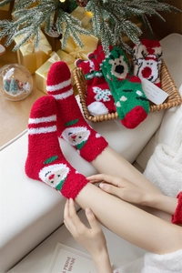 Close-up of thick coral fleece Christmas socks with festive embroidery on soft fabric