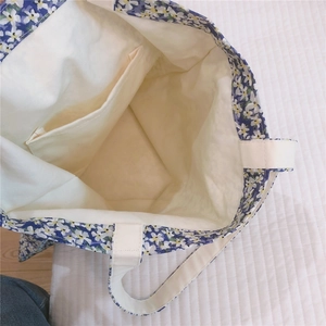 Detail view of floral canvas tote bag showing interior pocket and cream cotton lining