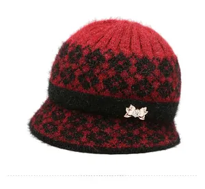 Close-up of red and black knit hat featuring fuzzy mohair texture and rhinestone bow