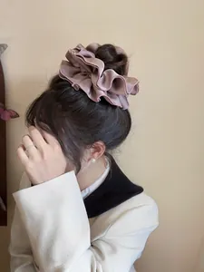 Macro shot of an elegant pink silk scrunchie with oversized ruffles and satin finish