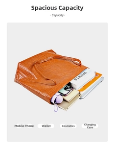 Detail view of large capacity brown crocodile pattern tote bag holding books and tablet