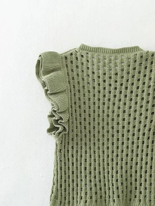 Detail of green knit top featuring breathable hollow mesh and ruffle flutter sleeves