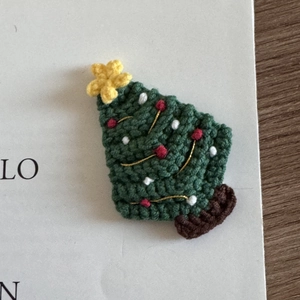 Detail of handcrafted crochet Christmas tree hair clip with festive star and bead accents