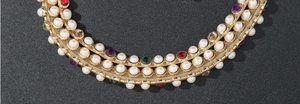 Macro shot of multi-layer pearl waist chain with colorful rhinestones on golden metal mesh
