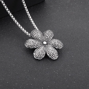 Macro detail of vintage silver flower turtle pendant with intricate textured petals