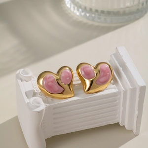 Detailansicht der herzförmigen Goldstecker mit rosa Marmoremaille auf einer Säule