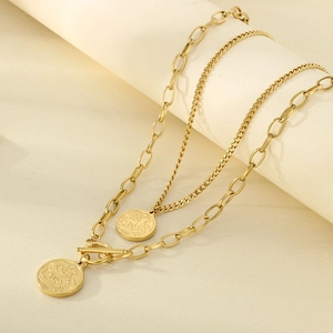 Close-up of golden layered necklaces with St. George coin pendants on a beige display