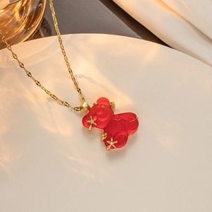 Detailed close-up of a red resin bear pendant with gold accents and sparkling crystals