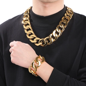 Polished gold Cuban link necklace and bracelet set displayed on a model in black