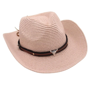 Close-up of a pink cowboy straw hat featuring a bull skull pendant and metal rivets