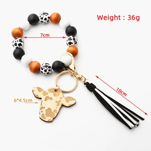 Detail showing cow print bead keychain dimensions with tassel and wooden charm