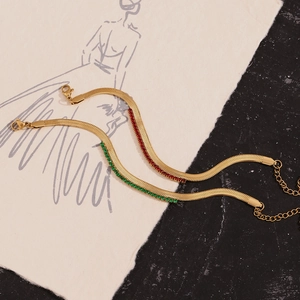 Detailed view of 18K gold plated herringbone chain with red and green zircon accents