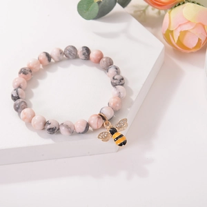 Detail of natural agate beads bracelet featuring a micro-set zircon bee charm with crystals