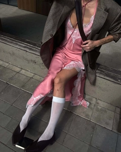 Détail d'une robe nuisette en soie rose avec bordure en dentelle et fente latérale