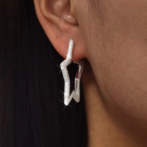 Close-up of sparkling star-shaped earrings with micro-pave cubic zirconia on a model
