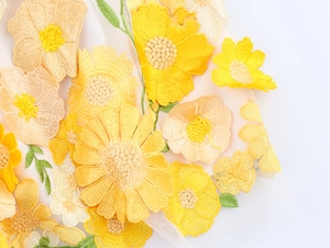 Détail macro de broderie florale 3D jaune de qualité sur tissu en maille transparente
