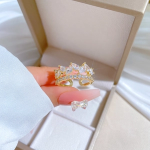 Close-up of golden crown ring with marquise cubic zirconia and adjustable band design