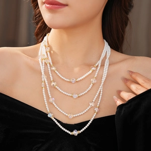 Détail d'un collier à quatre rangs en perles et cristaux avec entretoises dorées